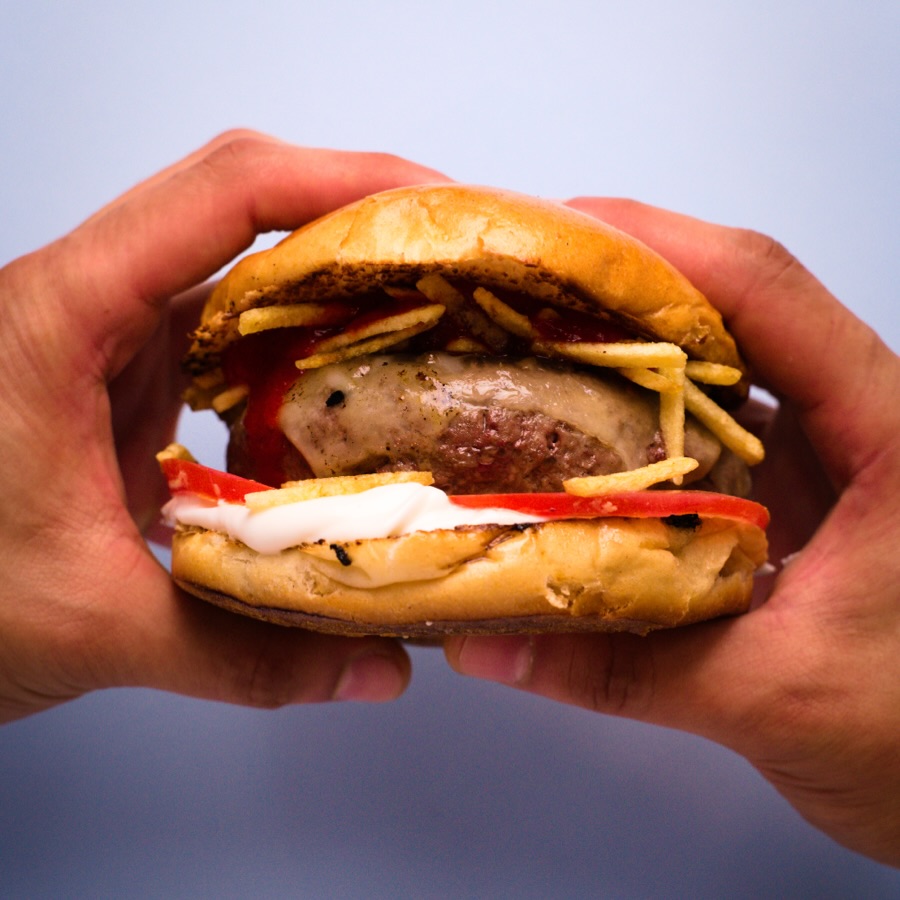 La Oasis Burger sujeta con las dos manos