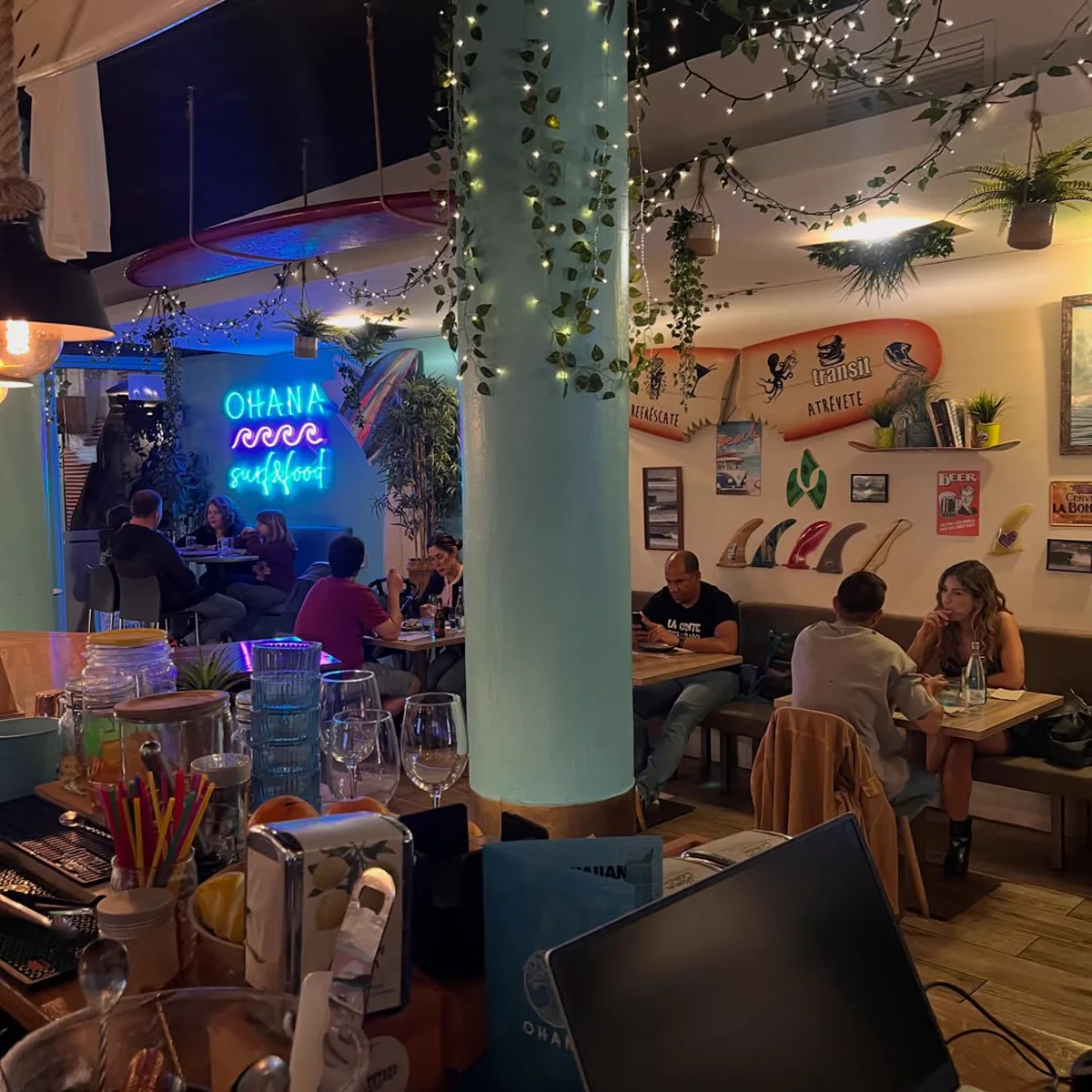 La sala de Ohana: columna turquesa, neón y plantas