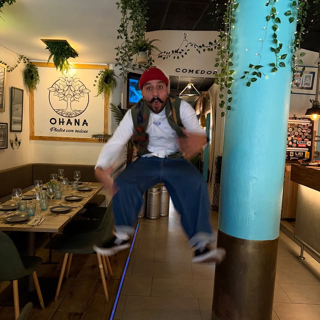 Jairo saltando delante de la columna turquesa del local